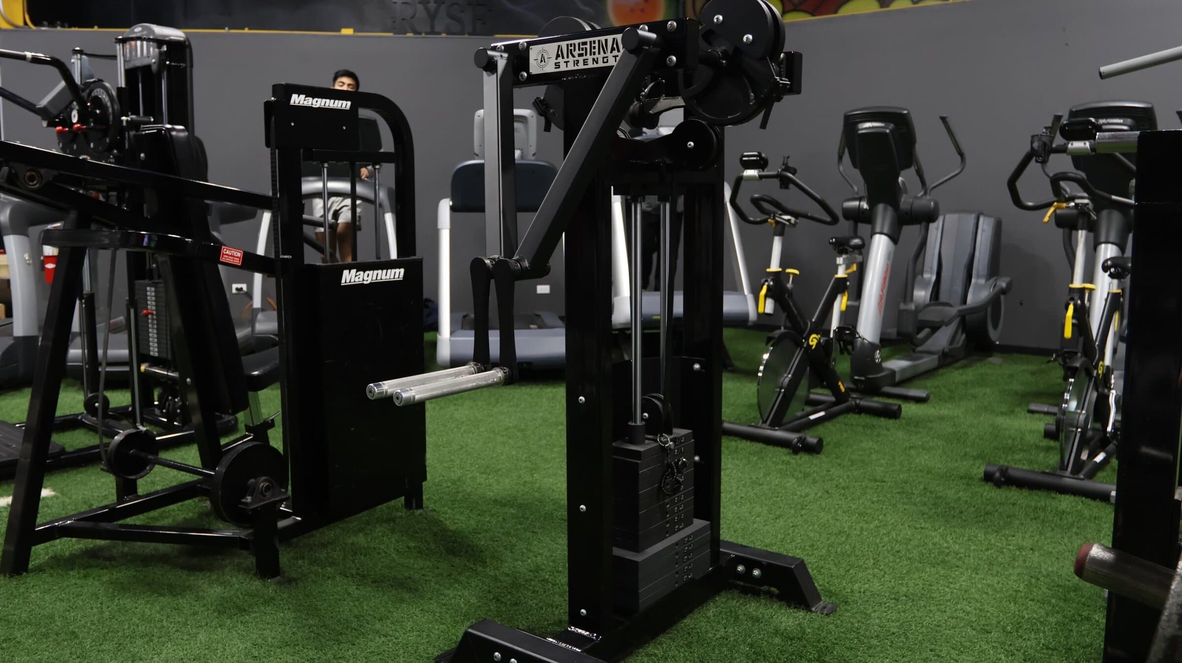 Wide view of the Ryse Athletic Club training floor with green turf and machines